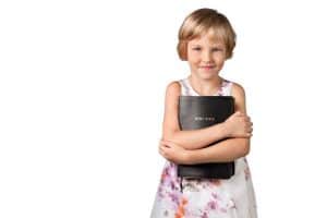 young girl holding bible - memorize the books of the Bible