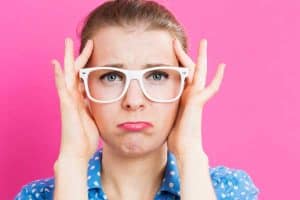 Woman stress and wants to simply your family life, blue shirt with glasses and a hot pink background.