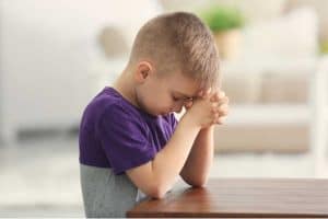Kid in purple shirt praying