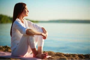 Christian Woman Meditating on a beach.