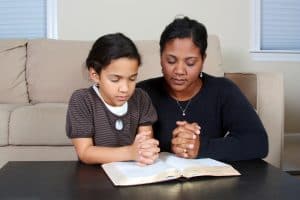 praying mom with young child